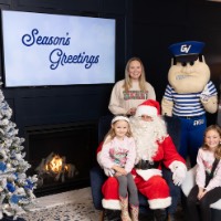 Louie the Laker and Santa with girls in pink sweaters and parents